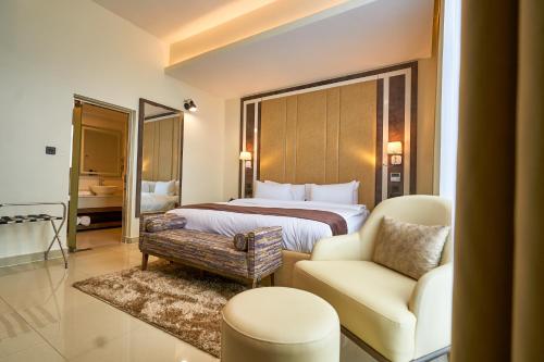 a hotel room with a bed and a chair at Monty Suites Lekki in Lagos