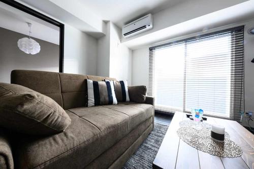 a living room with a couch and a table at Baycourt Otaru in Kita-hamachō