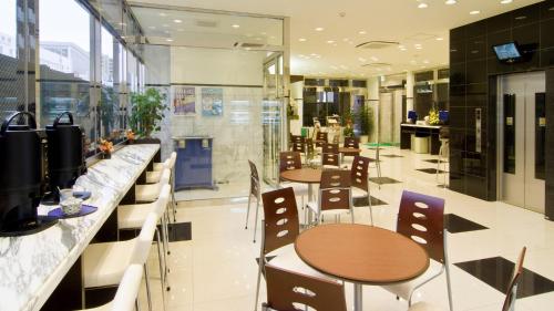 a restaurant with tables and chairs in a building at Toyoko Inn Shizuoka Fujieda eki Kita guchi in Fujieda