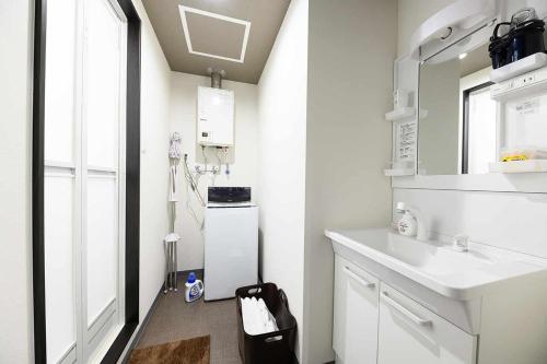 a white kitchen with a sink and a refrigerator at Baycourt Otaru in Kita-hamachō