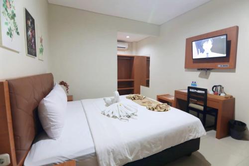 Ένα ή περισσότερα κρεβάτια σε δωμάτιο στο Lombok Mayura Hotel