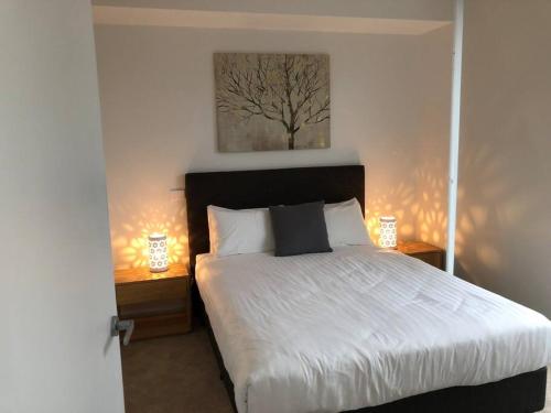 a bedroom with a bed with two night stands and two lamps at Beautiful Apartment in Chatswood in Sydney