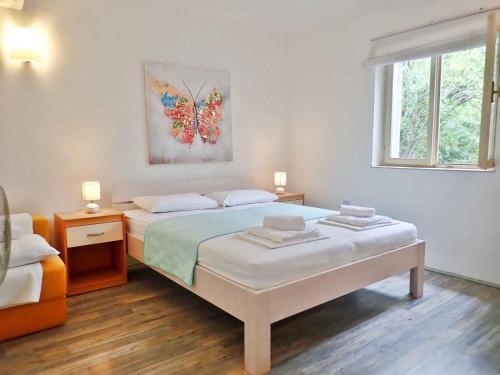 biała sypialnia z 2 łóżkami i oknem w obiekcie Apartment in Starigrad-Paklenica 34801 w mieście Starigrad-Paklenica