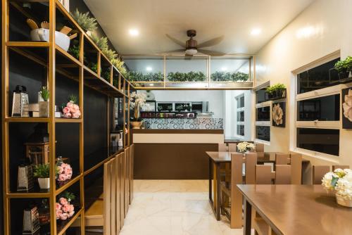 a dining room with a counter and tables and shelves at Monica Midtown Suites in General Santos