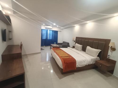 a bedroom with a bed and a desk and a couch at Sambodhi Retreat in Dhanbād