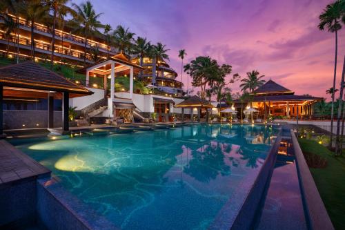 ein Resortpool mit einem Hotel im Hintergrund in der Unterkunft Taj Wayanad Resort & Spa, Kerala in Wayanad