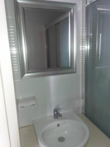 a white bathroom with a sink and a mirror at Mg Suite 1bedroom Apartment by Just Inn Management in Semarang