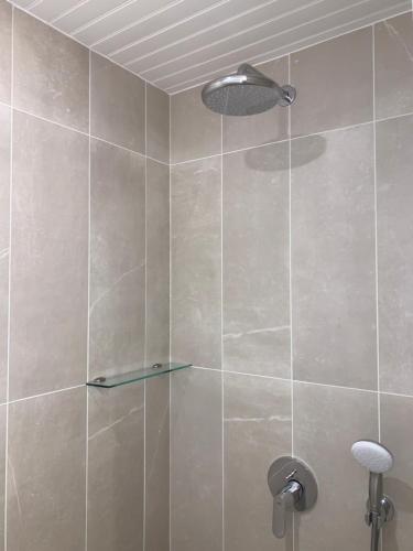 une douche avec une porte vitrée dans une salle de bain dans l'établissement La Métairie - Largilière, à Orx