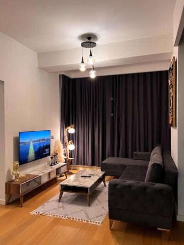 sala de estar con sofá y TV en Mükemmel konumda şehir manzaralı ve balkonlu daire, en Estambul