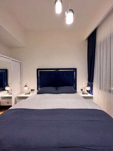 1 dormitorio con 1 cama grande, 2 mesas y 2 lámparas en Mükemmel konumda şehir manzaralı ve balkonlu daire, en Estambul
