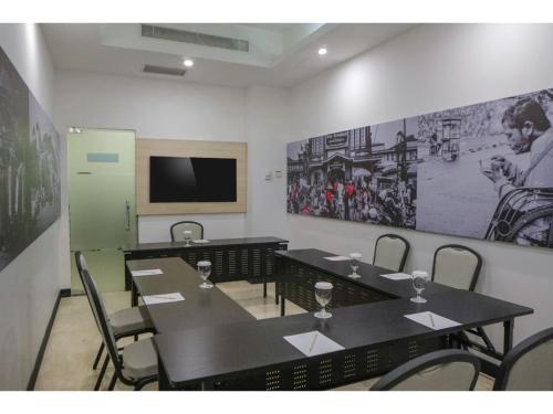a conference room with tables and chairs and a flat screen tv at Malyabhara Hotel - formerly Ibis Malioboro in Yogyakarta
