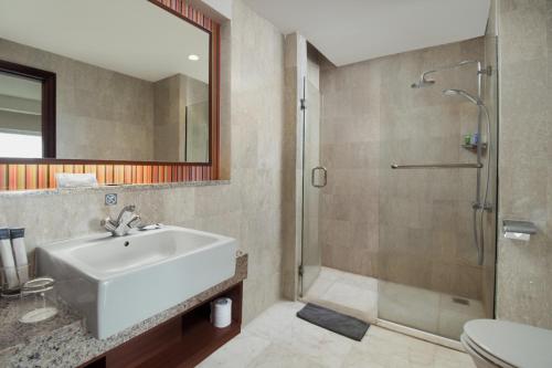 bagno con lavandino e doccia di ASTON Manado Hotel a Manado