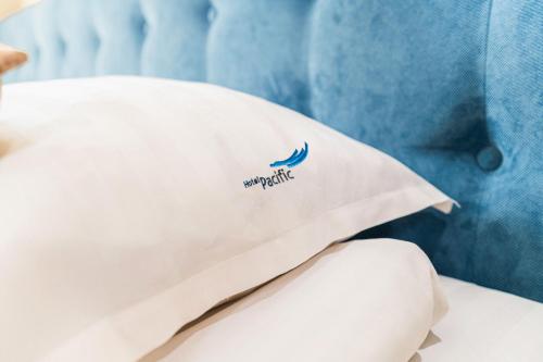 a pillow on a bed with a namisk logo on it at Hotel Pacific in Timişoara