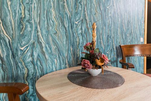 a wooden table with a vase of flowers on it at Hotel Pacific in Timişoara