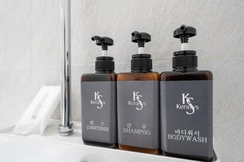 two bottles of soap on a shelf in front of a mirror at The Nox Hotel in Suwon