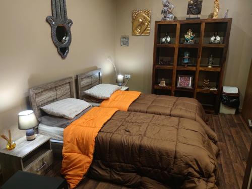 a bedroom with a large bed with an orange blanket at Lotus Guest House Malta in Il-Gżira