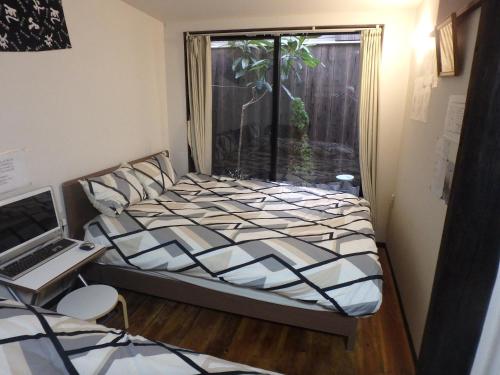 a bed in a room with a window and a desk at 京の宿 西大路 familie in Kyoto