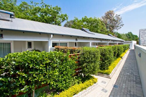 a building with a row of hedges in front of it at Kent Manor Guest Suites in Johannesburg