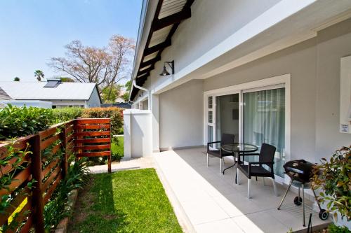 a patio with chairs and a table in a house at Kent Manor Guest Suites in Johannesburg