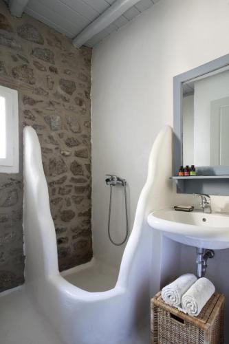 a bathroom with a white sink and a bath tub at Elegance Villa in Platis Gialos