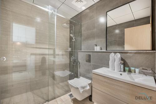 a bathroom with a shower and a toilet and a sink at Urban Studio at The Square Tower Jumeirah Village Circle by Deluxe Holiday Homes in Dubai