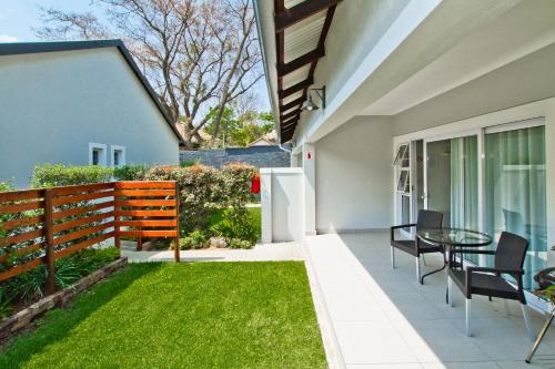 a patio with a table and chairs in a house at Kent Manor Guest Suites in Johannesburg