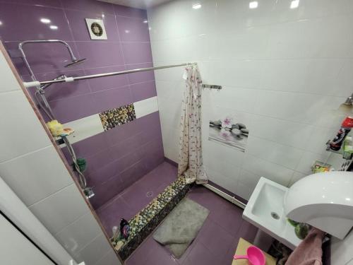 y baño blanco y morado con ducha y lavabo. en Karson Guest House and Tours, en Ereván