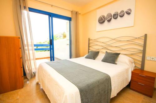 ein Schlafzimmer mit einem großen Bett und einem großen Fenster in der Unterkunft 2 bedrooms sea and pool view apt in Duquesa Golf & Gardens Manilva in Castillo de Sabinillas