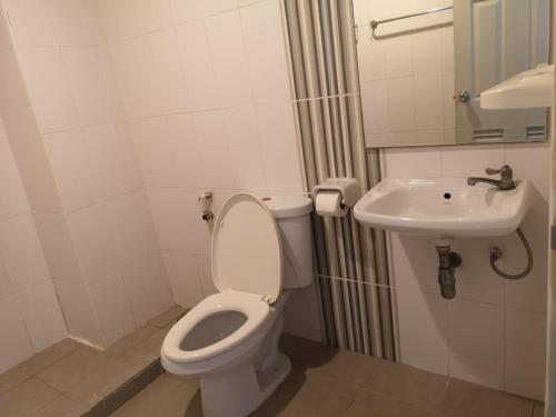 a bathroom with a toilet and a sink at Capital O 75415 Nanthachart Riverview Resort in Samut Songkhram