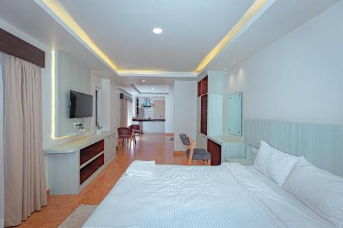 een hotelkamer met een bed en een televisie bij POMs Penthouse in Pokhara