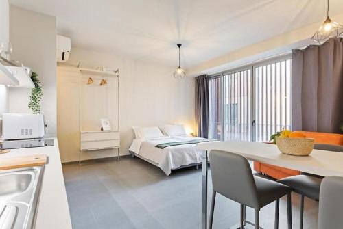a bedroom with a bed and a table and a kitchen at Etna Suite Design Apartments in Catania