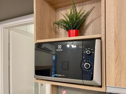 un forno a microonde in un armadio con una pianta di KamzikTower View - One a Nivy