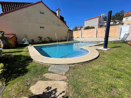 Apartamento con piscina privada في فيغو: مسبح في ساحة بجانب بيت