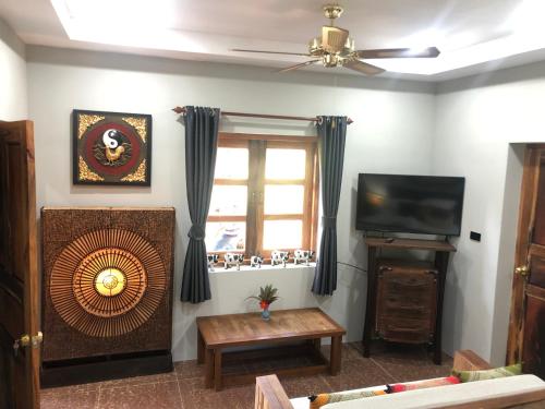 a living room with a fan and a television at On The Mekong Resort in Luang Prabang