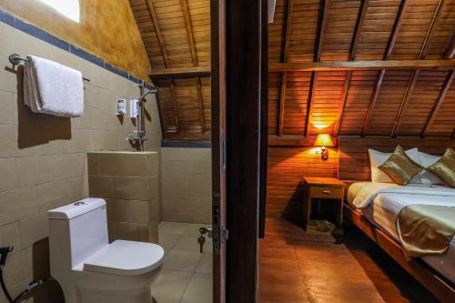 y baño con cama, aseo y ducha. en You and We House, en Nusa Penida