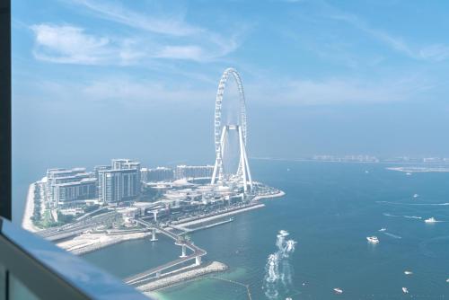 a ferris wheel in the middle of a body of water at Lux BnB I The Address JBR I Ocean View in Dubai