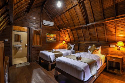 1 dormitorio con 2 camas y baño con ducha en You and We House, en Nusa Penida