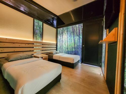 a bedroom with two beds and a large window at X Park Iskandar Puteri in Nusajaya
