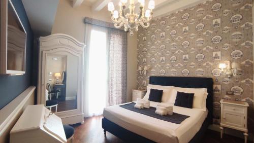 Un dormitorio con una cama grande y una lámpara de araña. en Dimora Bellini by Hotel Bellini sas, en Palermo