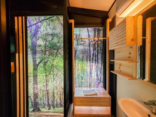 a bathroom with a view of a forest through a sliding glass door at X Park Iskandar Puteri in Nusajaya