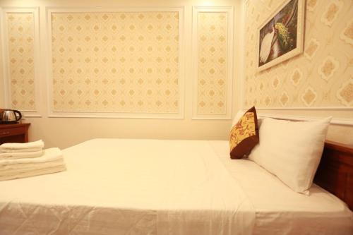 a bedroom with a bed with white sheets at THANH TAI HOTEl 1 in Ho Chi Minh City