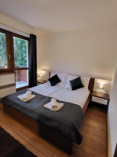 a bedroom with a bed with two towels on it at Kamzik Apartment hill view with garage in Donovaly