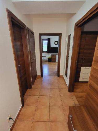 a hallway with wooden doors and a tile floor at Kamzik Apartment hill view with garage in Donovaly