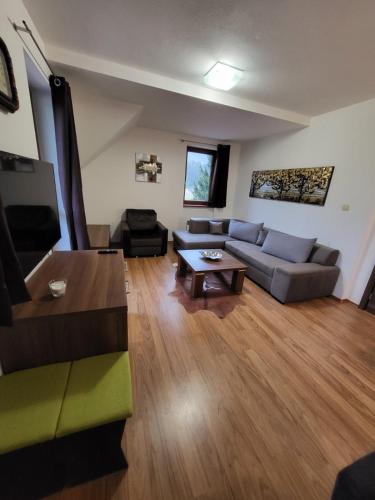 a living room with a couch and a table at Kamzik Apartment hill view with garage in Donovaly