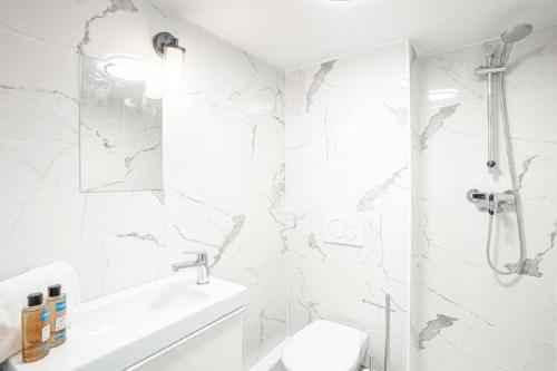 une salle de bain blanche avec toilettes et douche dans l'établissement 145 - Urban Pretty Studio in Center of Paris, à Paris