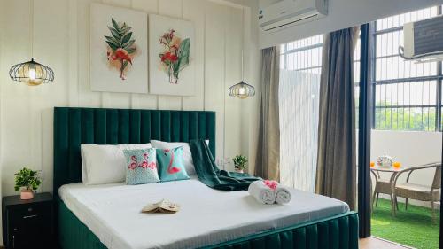 1 dormitorio con 1 cama grande y toallas. en Olive Service Apartments - City Centre Noida, en Noida