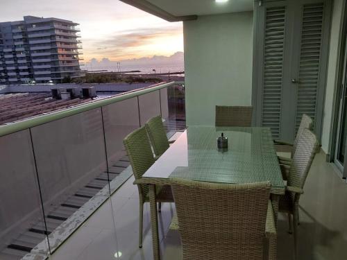uma mesa e cadeiras numa varanda com vista para o oceano em AZ Apartments em Cartagena das Índias