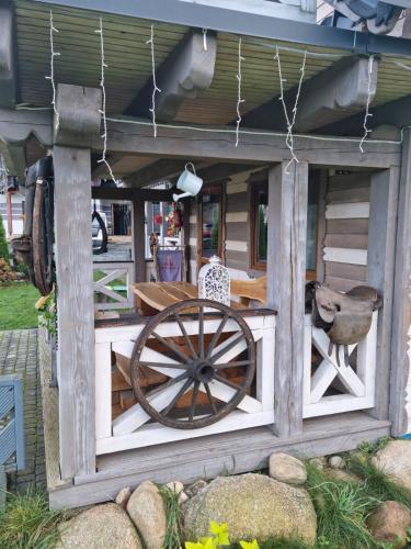 a wooden building with a wooden cart in a yard at Ostoja Karkonoska in Podgórzyn
