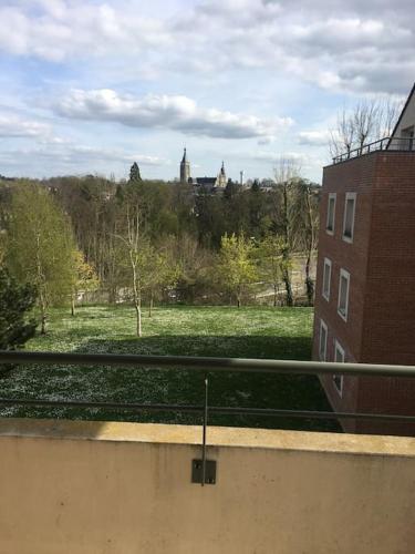 a view of a park with a building and a field at Appartement calme et lumineux 