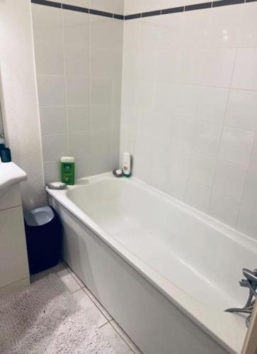 a white bath tub in a bathroom with a sink at Appartement calme et lumineux 